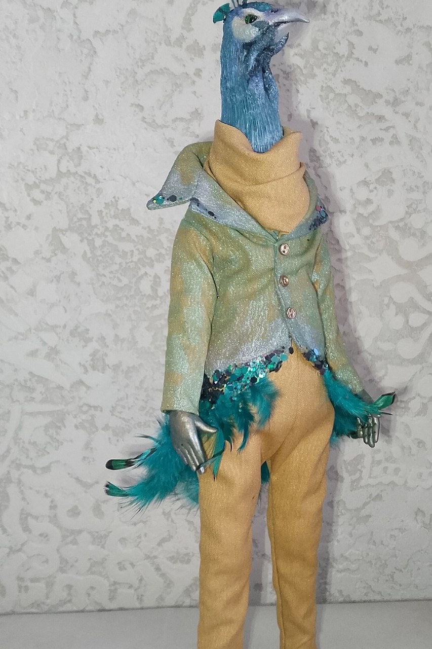 Синьор Паво и Магия Исчезающих Цветов**

В городе, где всё было серым и бетонным, жил один удивительный джентльмен по имени Синьор Паво. Никто не знал, откуда он пришел, но все замечали, как вокруг него меняется воздух — он начинал пахнуть озоном и старыми книгами.

Паво был не просто любителем моды. Он был **Хранителем Исчезающих Цветов**.

Вы замечали, как иногда выцветают старые фотографии? Или как тускнеет краска на заборе? Это не время виновато. Это маленькие невидимые жучки-серости крадут краски. И вот тут вступает в дело Синьор Паво.

Его пиджак, переливающийся зелено-серебристым блеском, был не из ткани. Он был сплетён из тысяч крошечных чешуек бабочек-сновидений и утренней росы. Каждая блестка на его одежде — это сохраненный кем-то яркий момент: первый поцелуй, смех ребенка, закат над морем.

Перья, торчащие из его манжет, служили ему кистями. Когда Паво взмахивал рукой, он мог «подкрасить» реальность.
— О, этот цветок совсем поблек, — шептал он, проводя пернатым пальцем по увядшему бутону. — Держи немного моего золота.

И цветок распускался вновь, сияя ярче, чем раньше.

Но у Паво была одна проблема: он тратил так много своих «запасных красок» на мир, что сам начал понемногу становиться прозрачным. Люди, проходившие мимо, иногда видели лишь вспышку бирюзового света и слышали тихий шелест перьев, но не могли разглядеть его самого.

Однажды маленькая девочка, рисующая мелом на асфальте, посмотрела прямо на него и сказала:
— У вас очень красивый пиджак, mister Peacock. Он сияет как моя мечта.

И в этот момент Синьор Паво почувствовал, как его фигура стала плотной и осязаемой. Оказалось, что внимание и восхищение — это единственная «краска», которой он не мог добыть сам, но которая питала его лучше всего.

С тех пор Синьор Паво ходит по городу, поправляя свой желтый воротник и сияя пайетками, в надежде, что кто-то еще заметит магию в повседневности.

🦚✨🎨